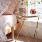 Приліжкові столики для спальні (40 фото): круглі скляні та ковані столи, білі і іншого кольору моделі на коліщатках