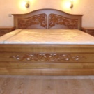 Різьблені ліжка (44 фото): моделі з масиву дерева, з різьбленим узголів’ям, дерев’яні двоспальні і односпальні моделі з різьбленням, дитячі ліжка