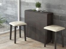 Розкладний обідній стіл-книжка для вітальні: як вибрати вузький стіл-трансформер для залу круглої і квадратної форми?